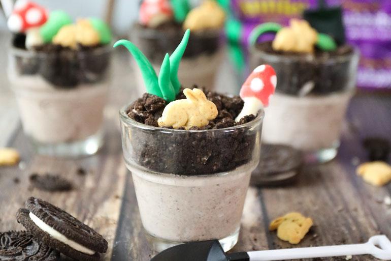Bunnies in the Garden served in small glass ramekins with a toy shovel beneath the foremost ramekin.