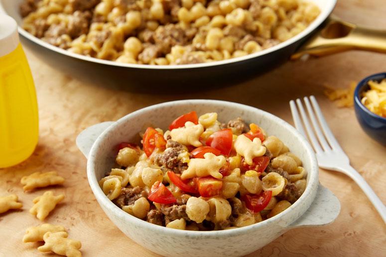 A bowl of an Annies recipe Cheeseburger Mac & Cheese with a white fork